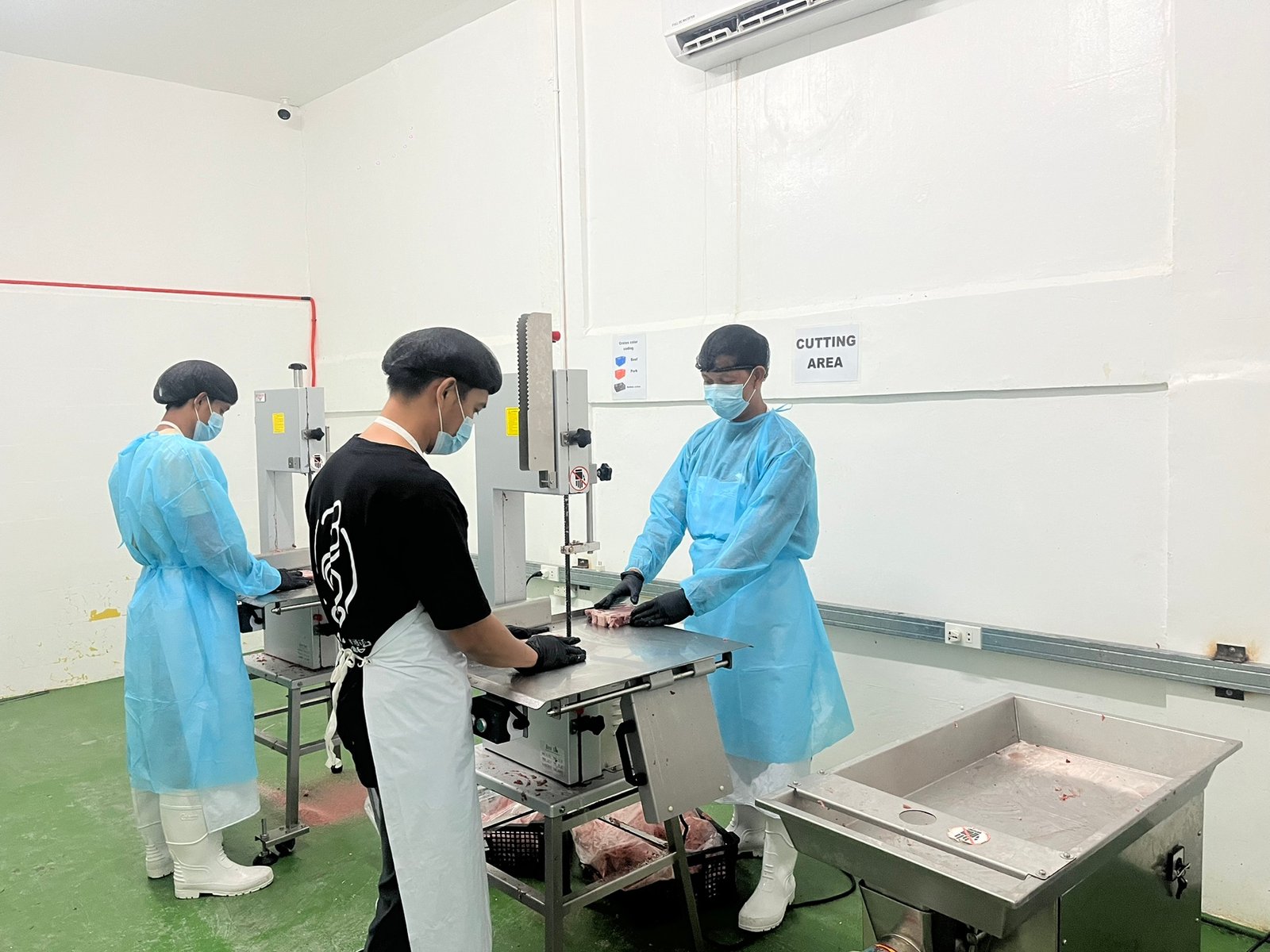NE Meats staff at the band saw in the cutting area