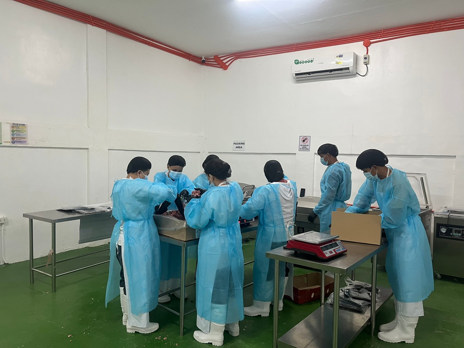 NE Meats staff weighing and packing orders in the packing area